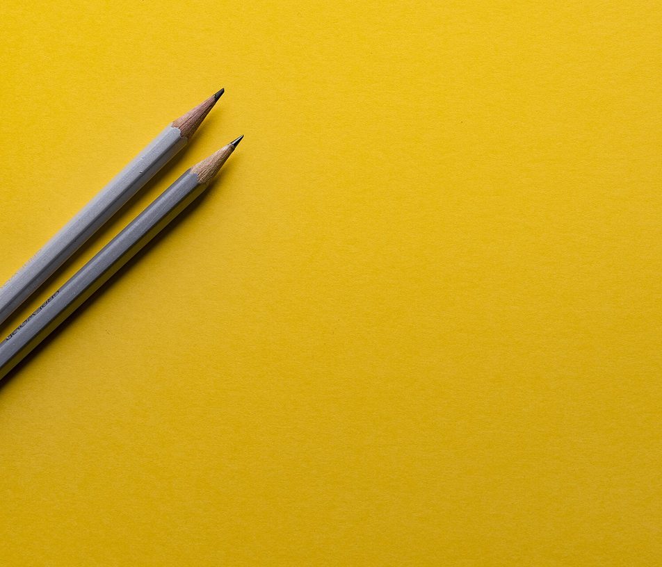 Dua pensil di atas kertas kuning